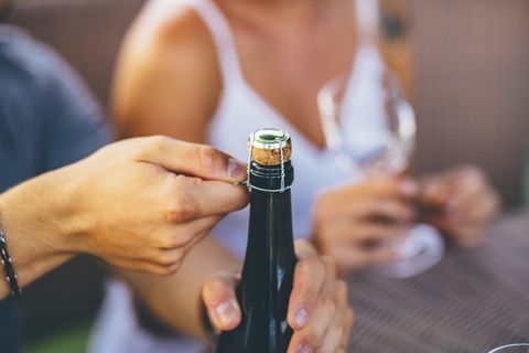 Romantik Çift bir açık hava partisinde bir şarap şişesi açılıyor